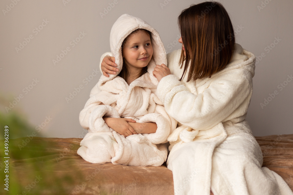 mother and daughter in bathrobes at home mother and daughter in bathrobes at home