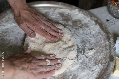 Hands knead the dough for further baking