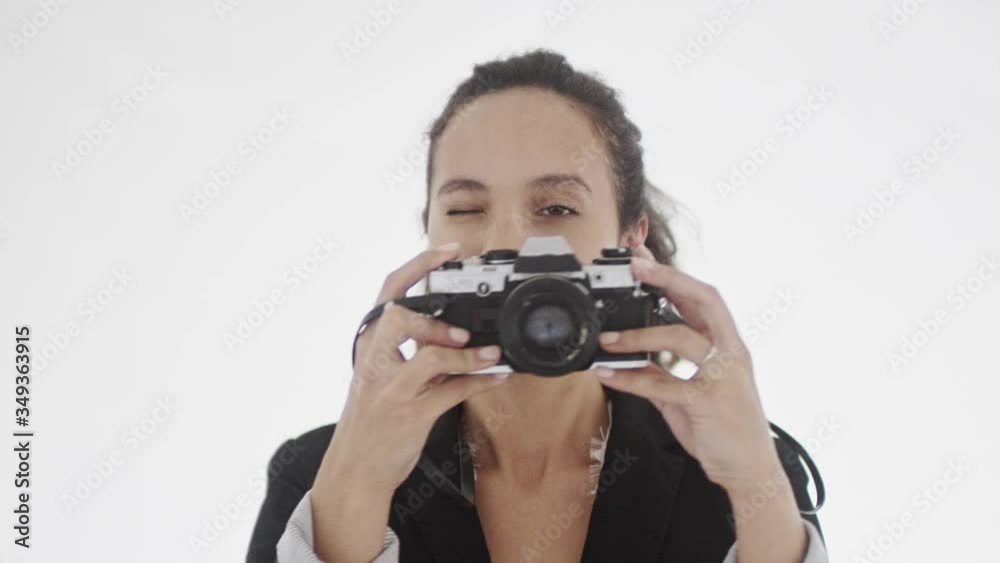 4K portrait of young beautiful dark-haired female with ponytail holding camera looking into eyepiece and taking photos. 360 degree tracking arc shot movement. 4K portrait of young beautiful dark-haired female with ponytail holding camera looking into eyepiece and taking photos. 360 degree tracking arc shot movement.