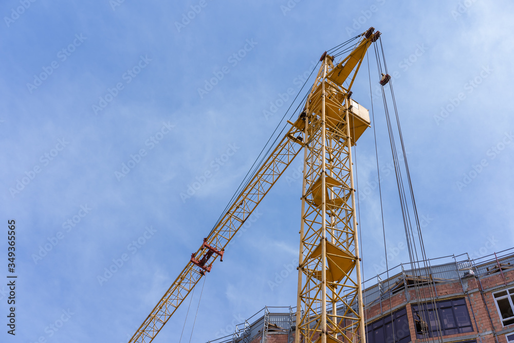 Construction crane near the building against the sky