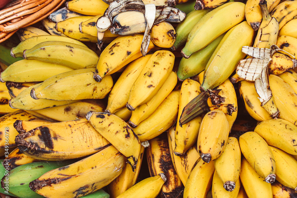 Clusters of ripe yellow bananas photographed on a fruit market. Overripe banana. Tropical fruits. Healthy lifestyle concept, source of vitamins.