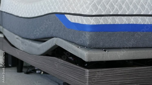 Adjustable mattress base lowering in slow motion moving along side the frame.