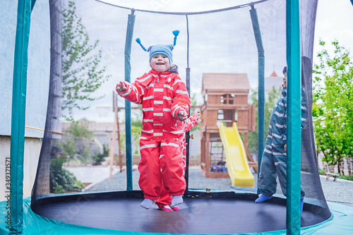 little girl with down syndrome jumps on a trampoline. she's happy.