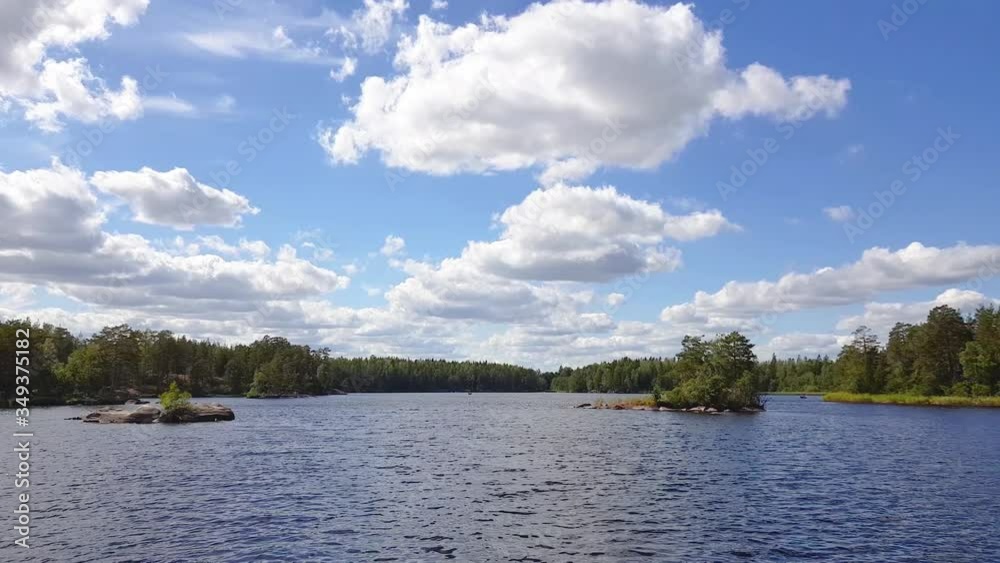 Beautiful nature landscape view . Lake with rocky coast line, blue water surface and green trees on blue sky with white clouds background. Sweden, Europe. Beautiful nature landscape view . Lake with rocky coast line, blue water surface and green trees on blue sky with white clouds background. Sweden, Europe.