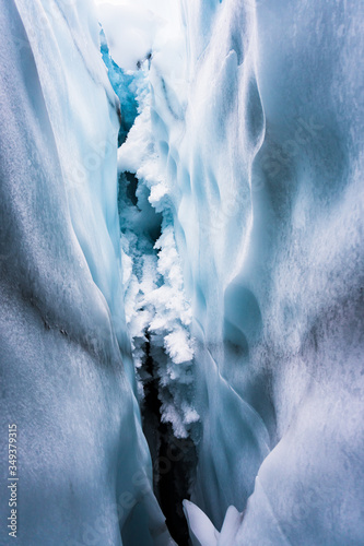 Close up in the inside of an ice cave in Matanuska Glacier, Alaska. Snowflakes on the ceiling. Details of the surface of the ice; texture. Taken during a trek in winter holidays. Cold cavern.  photo