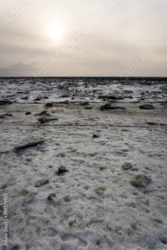 Frozen beach with its ice breaking and melting on the coast of Anchorage, Alaska. Beautiful landscape showing global warming and climate change. Instead of sand, there's snow, ice and rocks. Kincade.