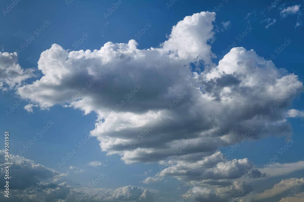 Fototapeta premium Lonely white cumulus cloud in a blue spring sky. Nature background.