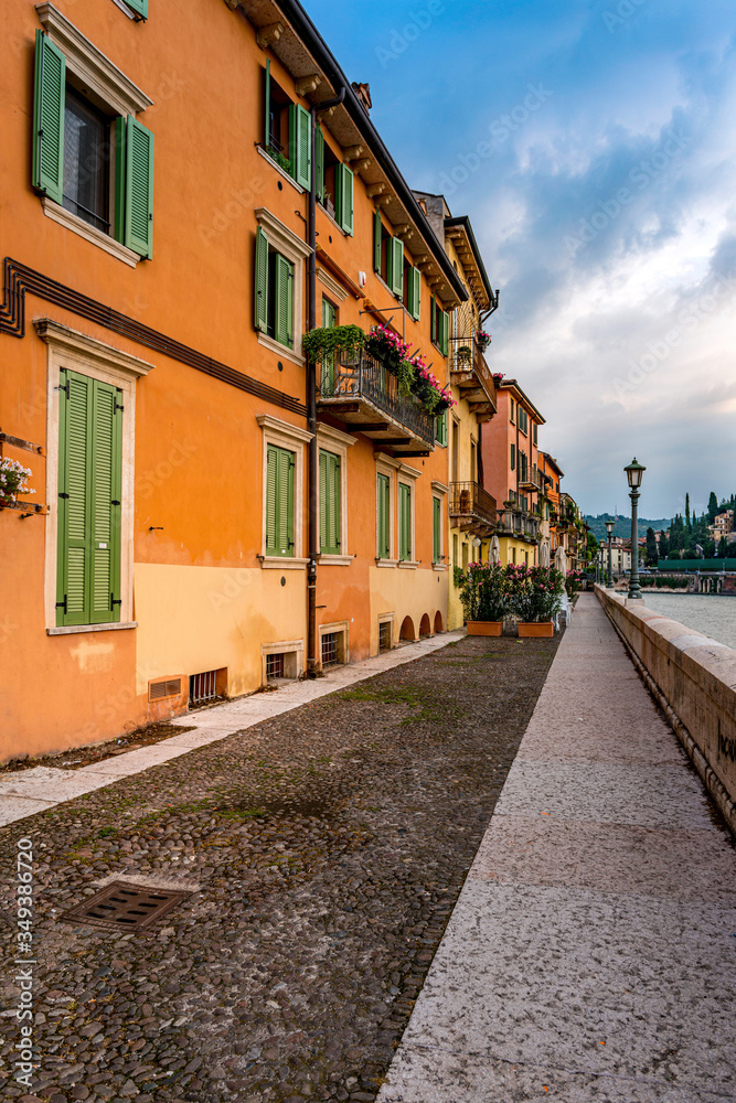 A narrow walkway along the Adige River in Verona Italy