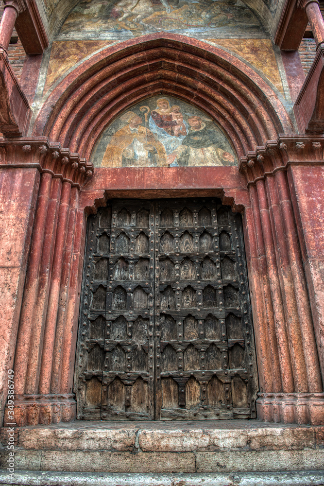 A very old medieval weathered door to a church in Verona Italy