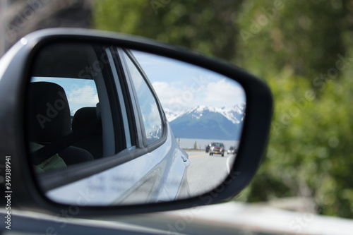 View of snow capped mountains from the rear view side view mirror © Dennis M. Swanson