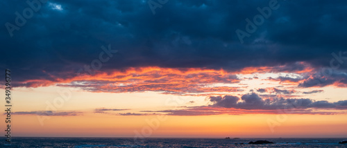 Wide sunset sky with vivid colors over ocean