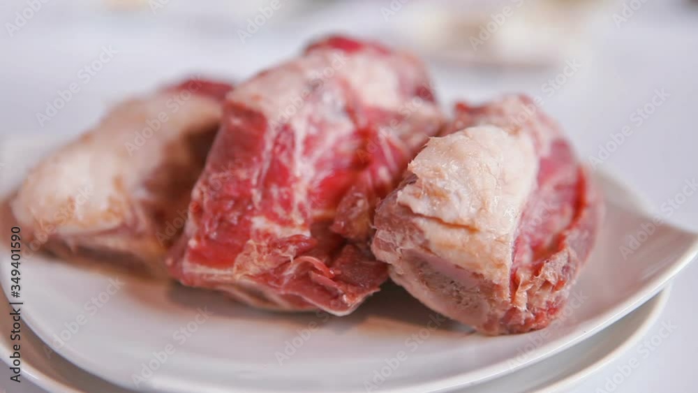 Close Up Of Raw Lamb Shank On White Plate, slider shoot Close Up Of Raw Lamb Shank On White Plate, slider shoot