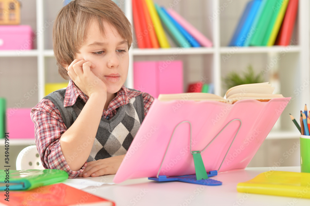 Portrait of tired little schoolboy doing his homework Portrait of tired little schoolboy doing his homework