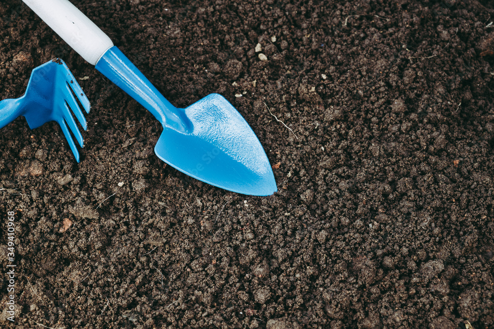 Agricultural equipment shovel and harrow on dark wet soil ground