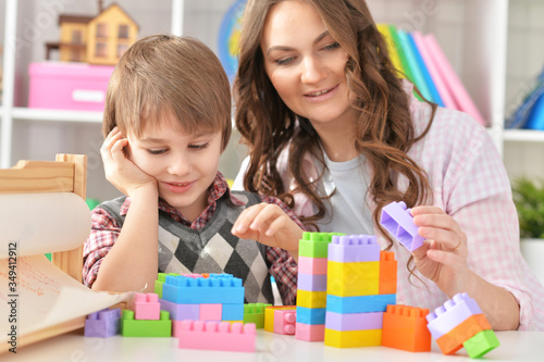 Close-up portrait of woman and boy playing blocks game