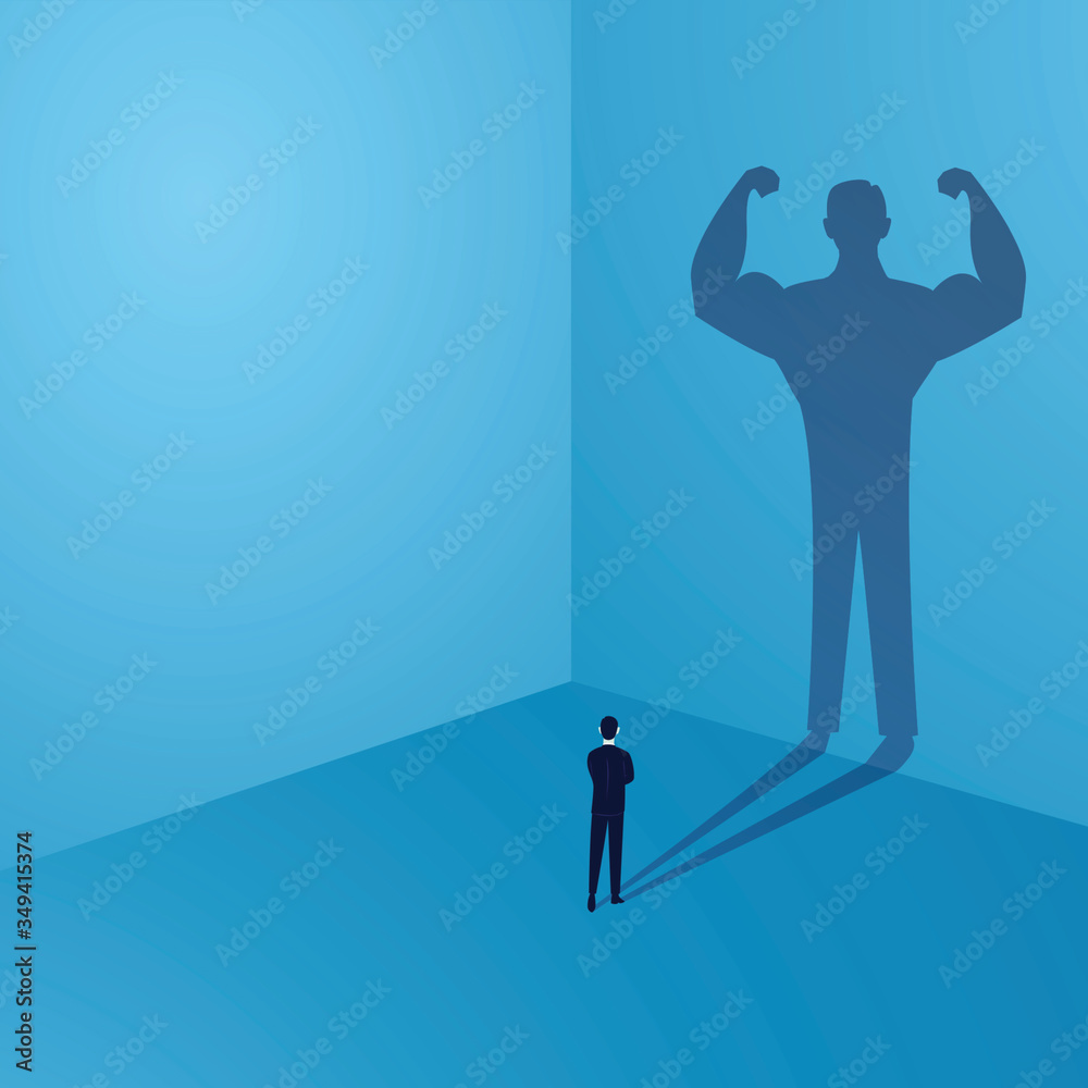 Businessman looking at his own strong personality shadow on wall, inner power concept