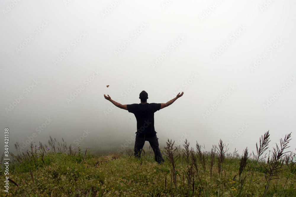 man isolated feeling the serene nature at hill top with amazing cloud layers in foreground man isolated feeling the serene nature at hill top with amazing cloud layers in foreground
