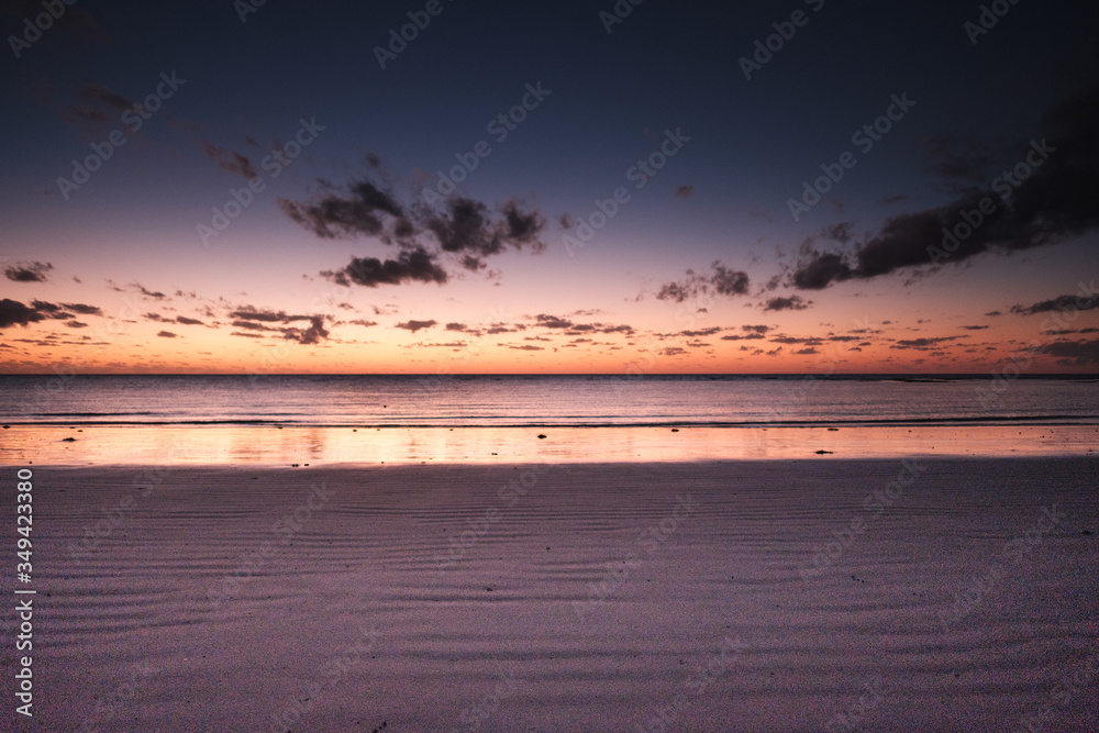 Obraz premium Beautiful orange sunrise over the ocean in far north Queensland, white sandy beach