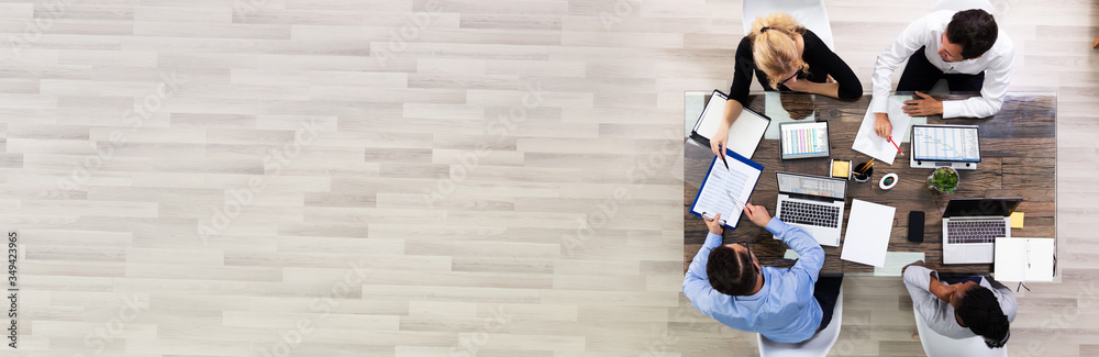 © Andrey Popov - Young Businesspeople Discussing Data In Meeting Room