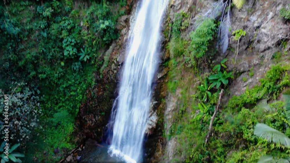 Aerial, tilt down, drone shot following a waterfall, in a jungle, sunny day, in Chiang Rai, Thailand Aerial, tilt down, drone shot following a waterfall, in a jungle, sunny day, in Chiang Rai, Thailand