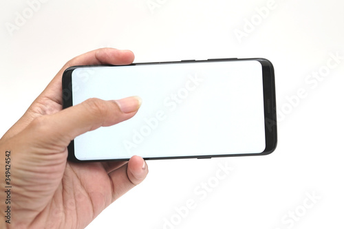 Hand with blank smart phone on landscape mode with thumb touch screen for mock up
