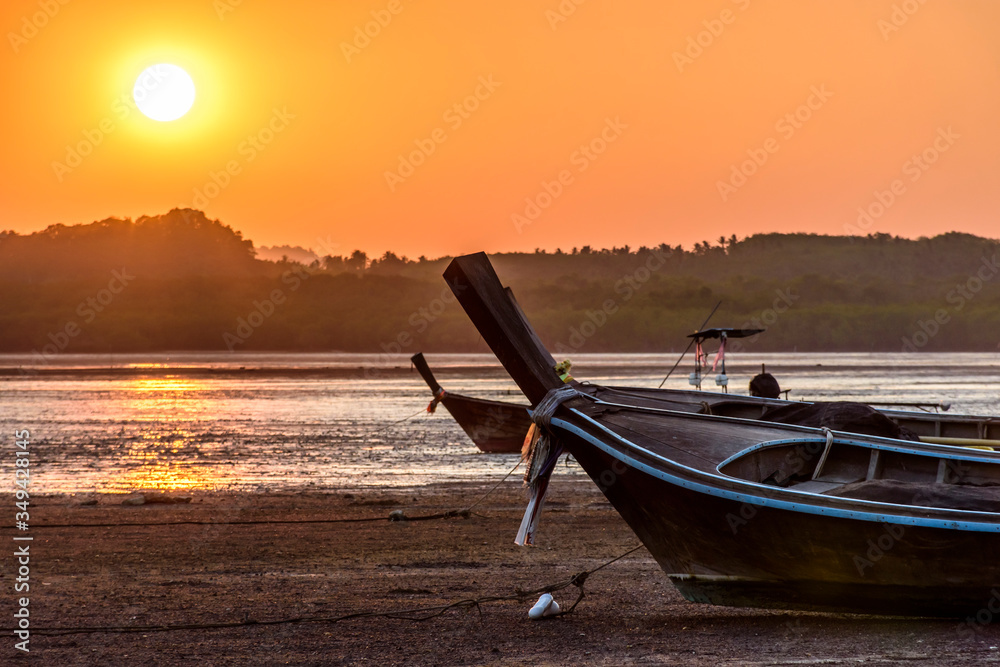 Long-tail boats at low tide at sunset on Ko Yao Noi island in Phang-Nga Bay near Phuket in southern Thailand