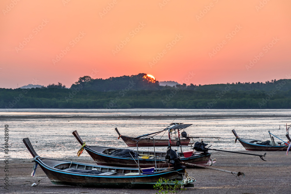 Long-tail boats at low tide at sunset on Ko Yao Noi island in Phang-Nga Bay near Phuket in southern Thailand