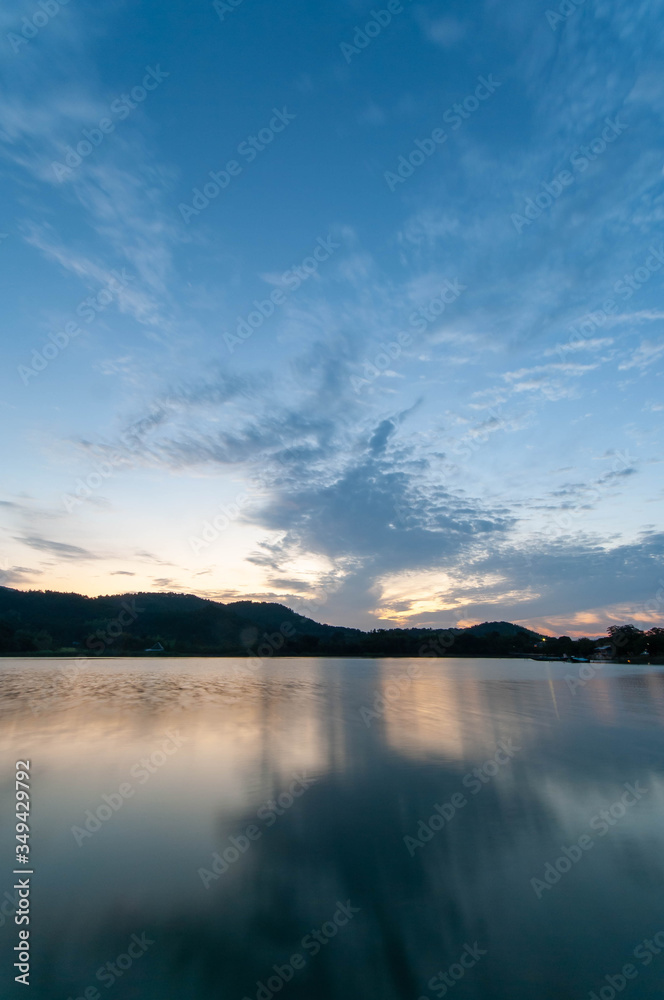 京都の池の水面に映る朝焼けの雲