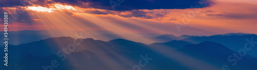 sunbeams through the clouds at sunrise on the snowy mountain