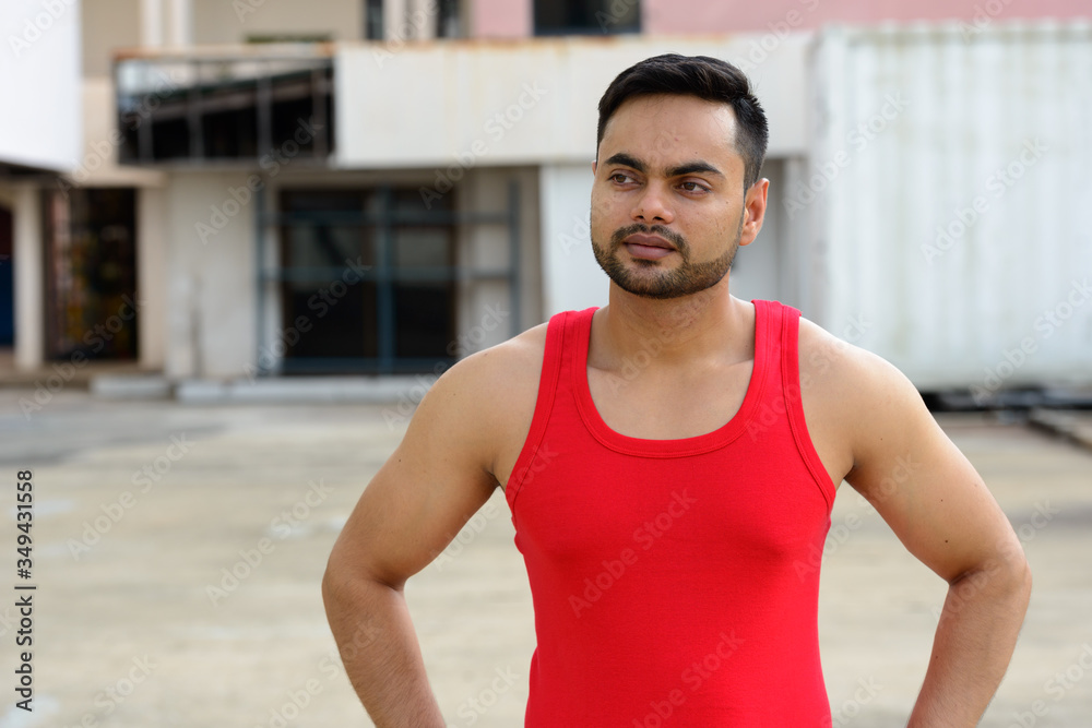 Young bearded Indian man ready for gym outdoors