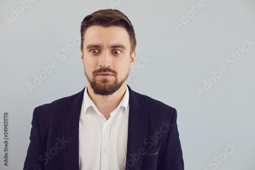 Foto Puzzled insecure man in casual jacket on a gray background