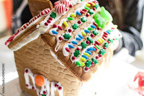 Gingerbread house while being decorated by a kid