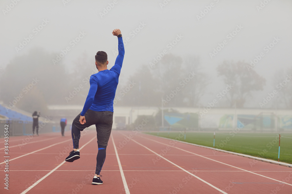The guy the athlete raised his hands up at the stadium in the fog.