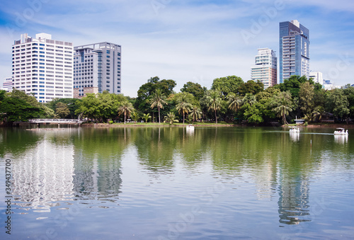 Palm trees and skyscrapers near the lake. View from the other side of the lake.