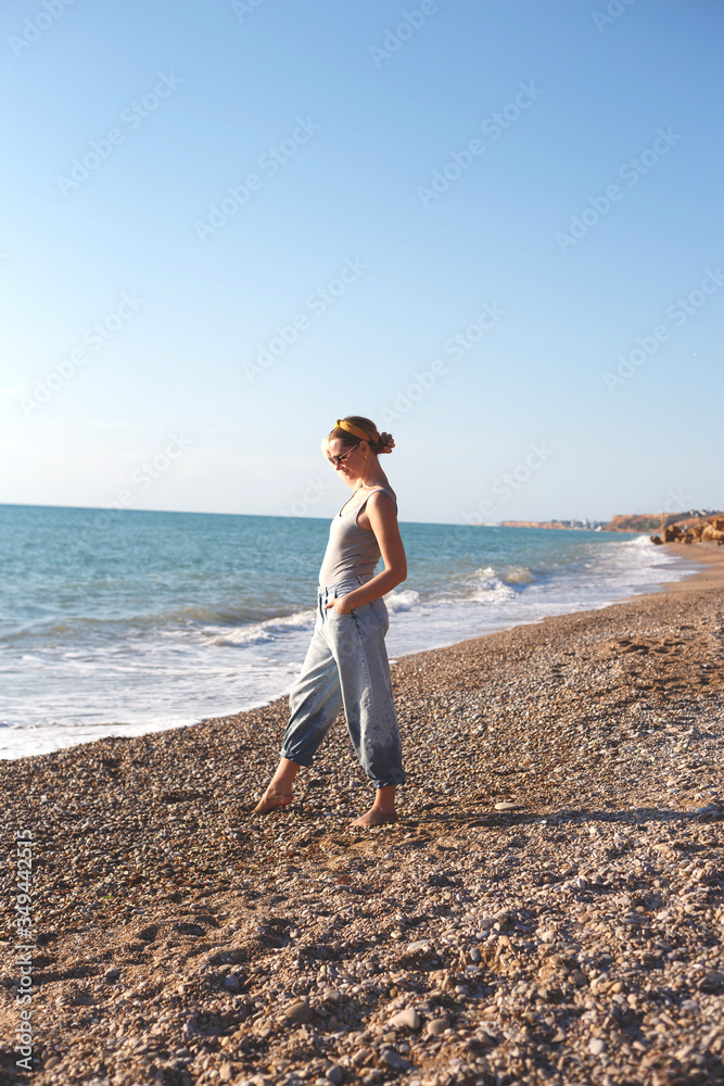 happy woman walks barefoot on the sand by the sea