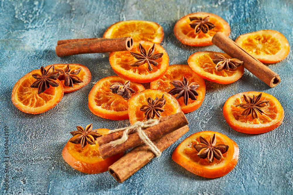 Slices of dried oranges or tangerines with anise and cinnamon, on a blue background. Vegetarianism and healthy eating