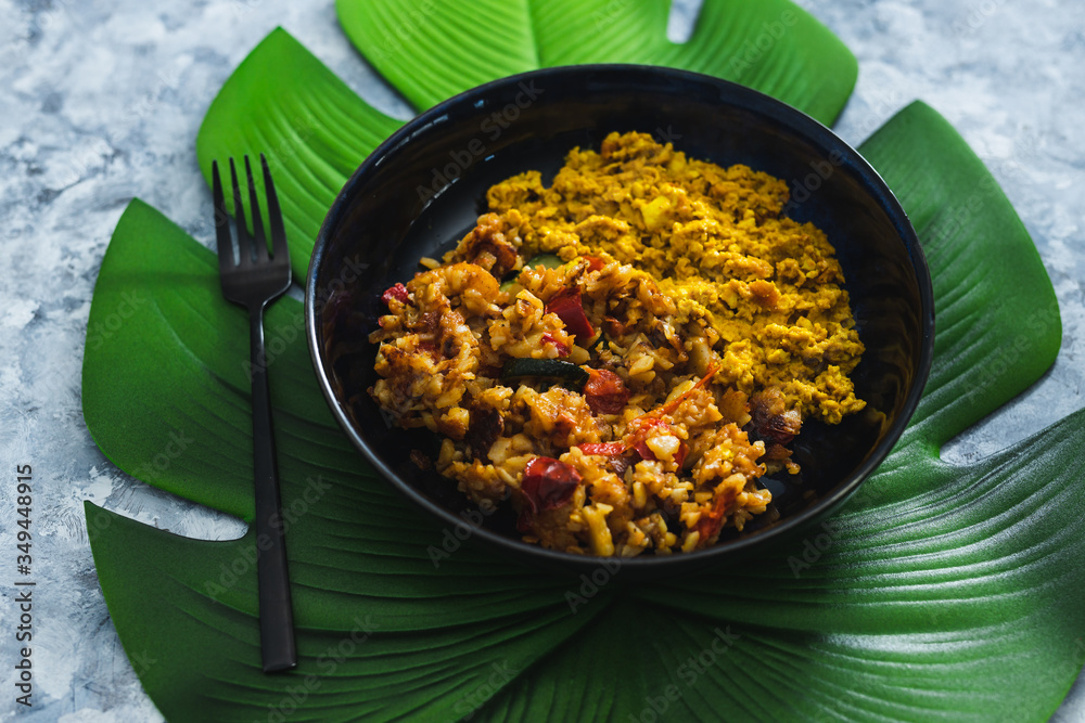 plant-based food, vegan scrambled tofu with mediterranean veggies and potatoes on leaf-shaped placemat