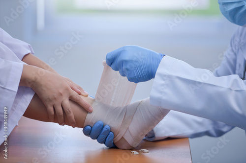 Feet holding with doctor,doctor analyzes and explains pain in the bones of the patient's feet.Doctor the traumatologist examines the leg examined at the medical office