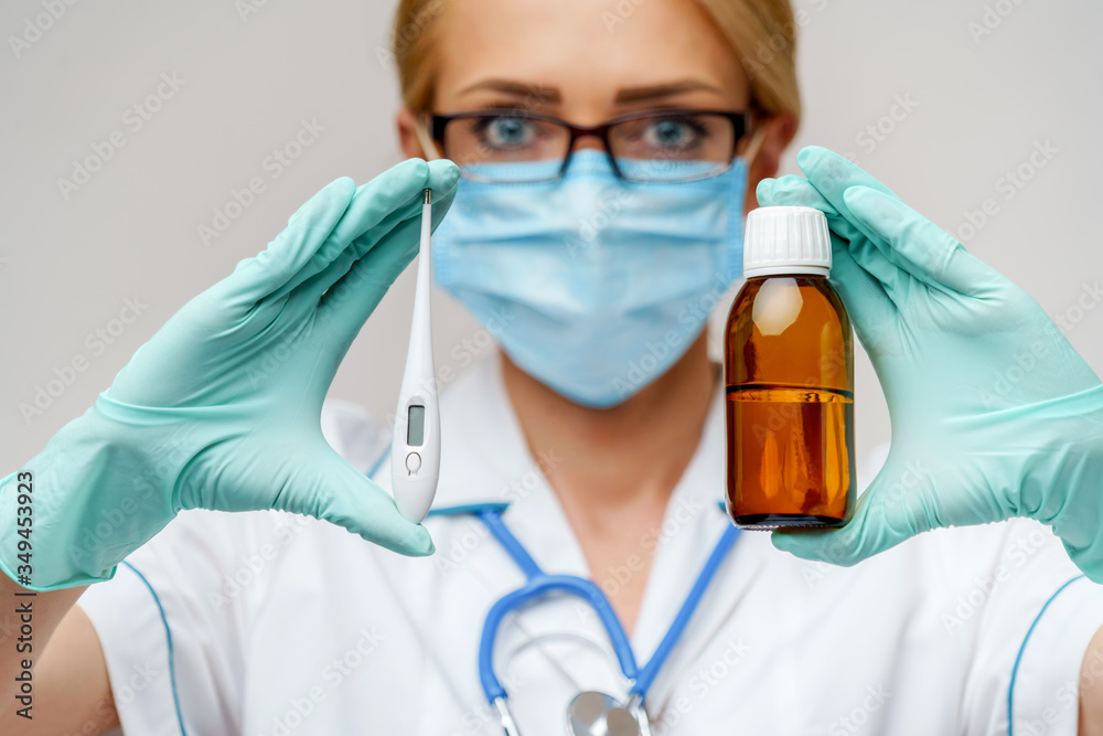medical doctor nurse woman wearing protective mask and rubber or latex gloves - holding can of medicine and thermometer medical doctor nurse woman wearing protective mask and rubber or latex gloves - holding can of medicine and thermometer