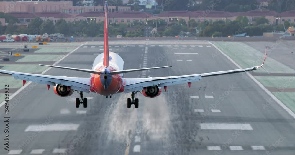 The view of a plane landing at a major international airport. The plane approach the runway and lands at the center. The other aircraft is seen at the background rising into the sky. 4K