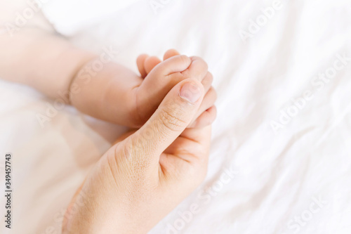 Soft focus of baby hands and mom, New family and baby protection concept, baby in the hand of mother close up, Parent holds Baby Hand Closeup
