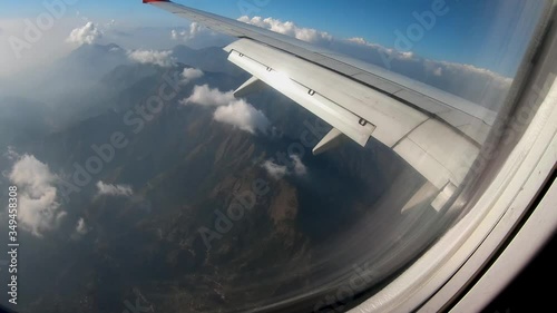 Window view airplane flying over the hilly region of Nepal while landing at Kathmandu Airport. photo