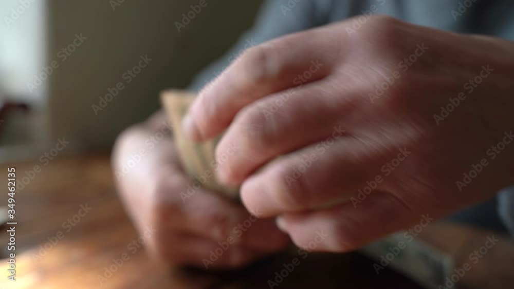 Elderly poor woman pensioner counts dollar bills of small denomination Elderly poor woman pensioner counts dollar bills of small denomination