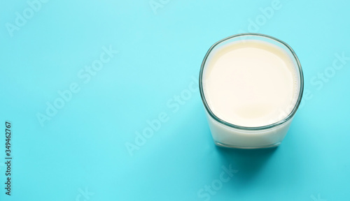 Glass of milk on blue background.