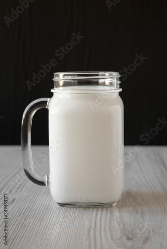 Coconut milk in a glass jar mug  side view.