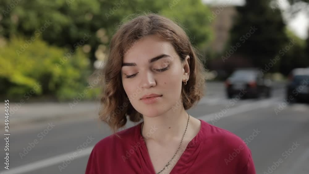 Portrait of beautiful woman model staring at camera looking confident standing in a city street against car traffic background Portrait of beautiful woman model staring at camera looking confident standing in a city street against car traffic background