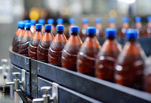 industrial food production of beer. Plastic beer bottles on a conveyor belt in the background of a brewery