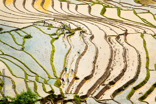 Y TY, LAO CAI, VIETNAM - MAY 9, 2020: Ethnic farmers working in a traditional way on terraces for a new crop utilizing natural water from mountains.
