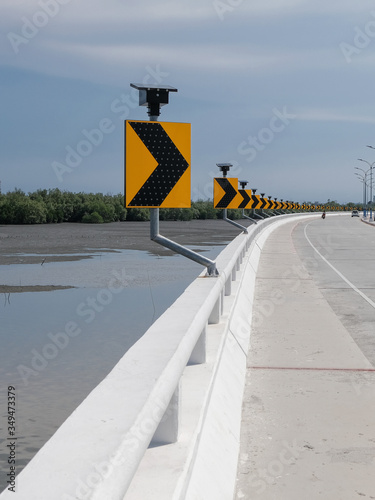 Road sign warn drivers for ahead dangerous curve road on coastal winding road