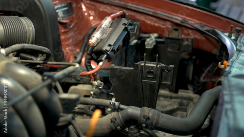 Professional mechanic repairing car engine. Close up hands of a repairman are fixing car motor.